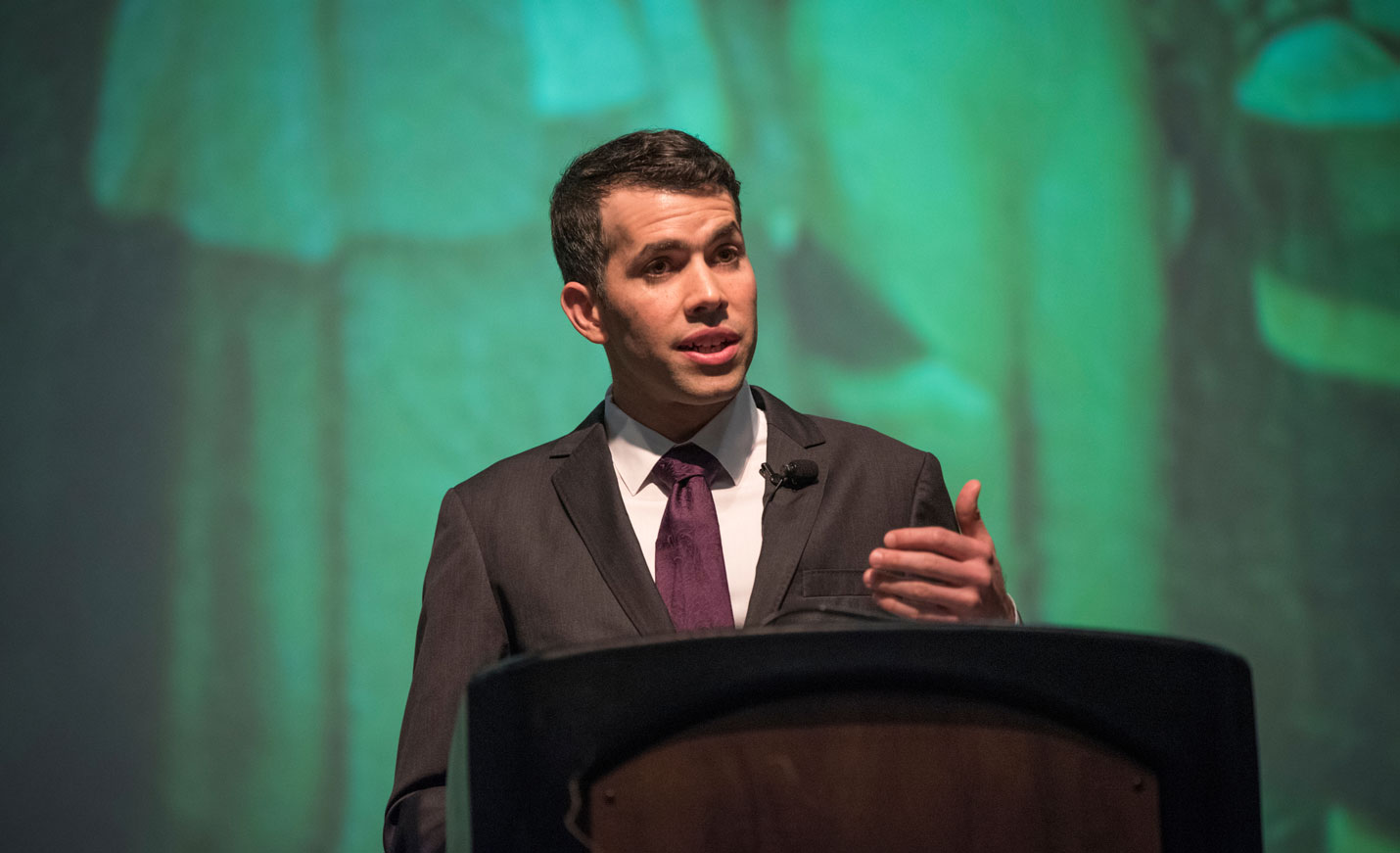 Sherman Lecture Keynote Speaker at podium with green background