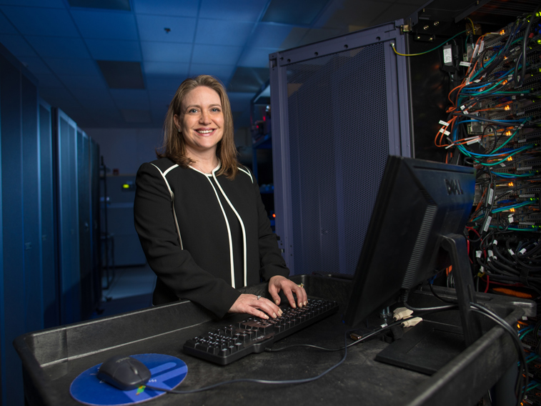 Sharyne Miller standing in front of a laptop computer