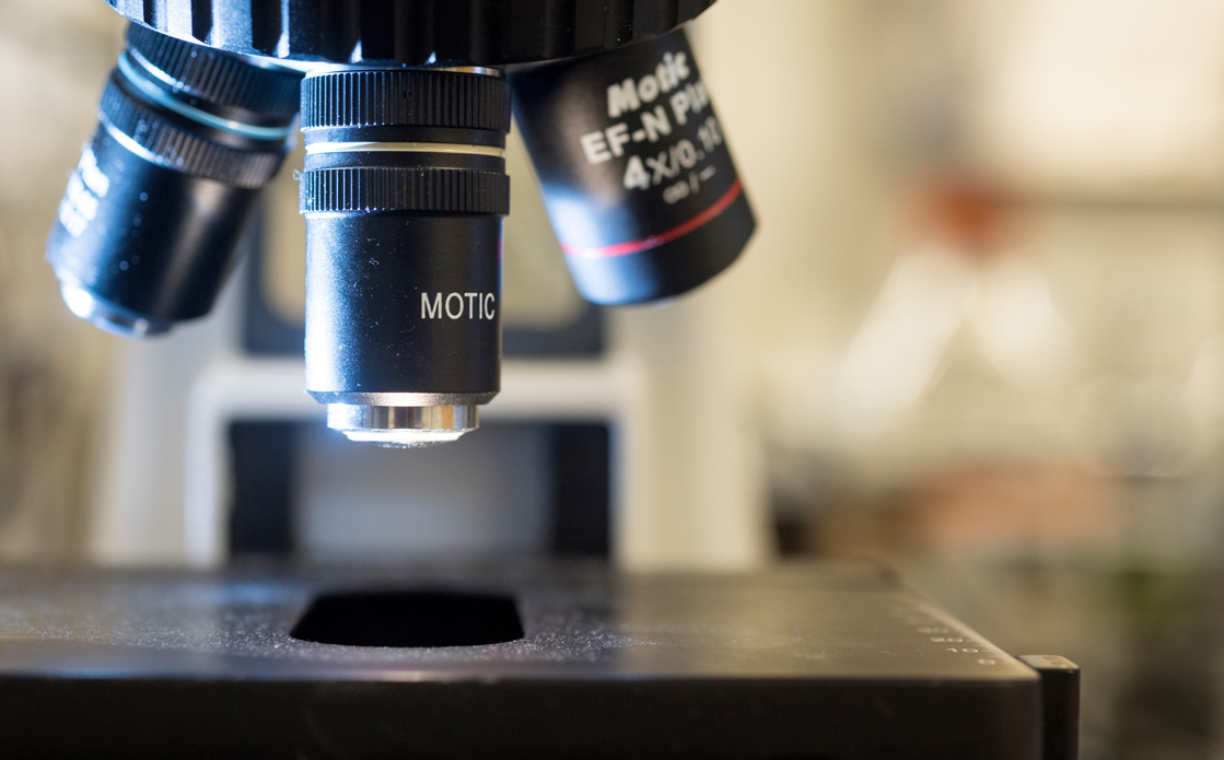 A close up photo of a microscope in a science lab.