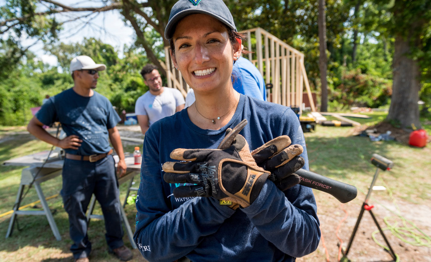 Woman on a construction site giving the uncw seahawk hand signal