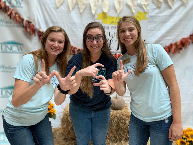 Students holding up the letters W, S, and L with their hands