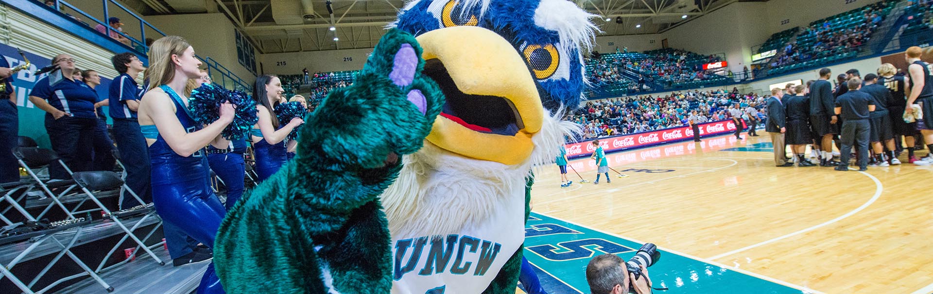 Sammy and cheerleaders at basketball game in Trask Coliseum