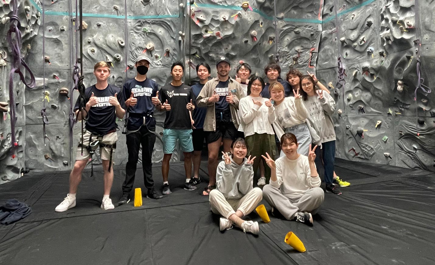 Group of people posing in front of climbing wall