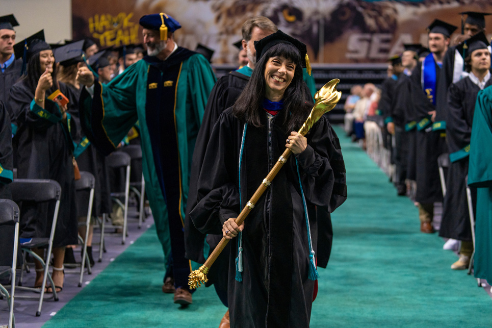 Faculty member carrying mace at commencement