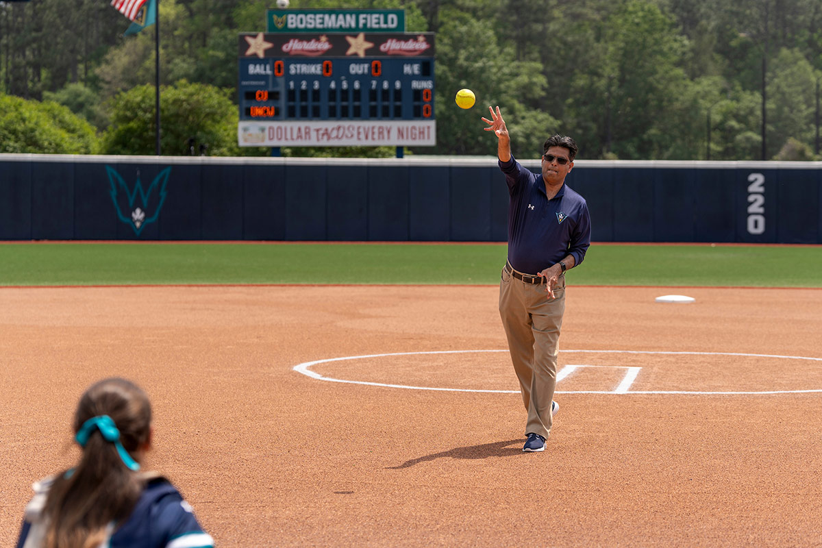 Chancellor Volety throws out the first pitch in softball at Boseman Field