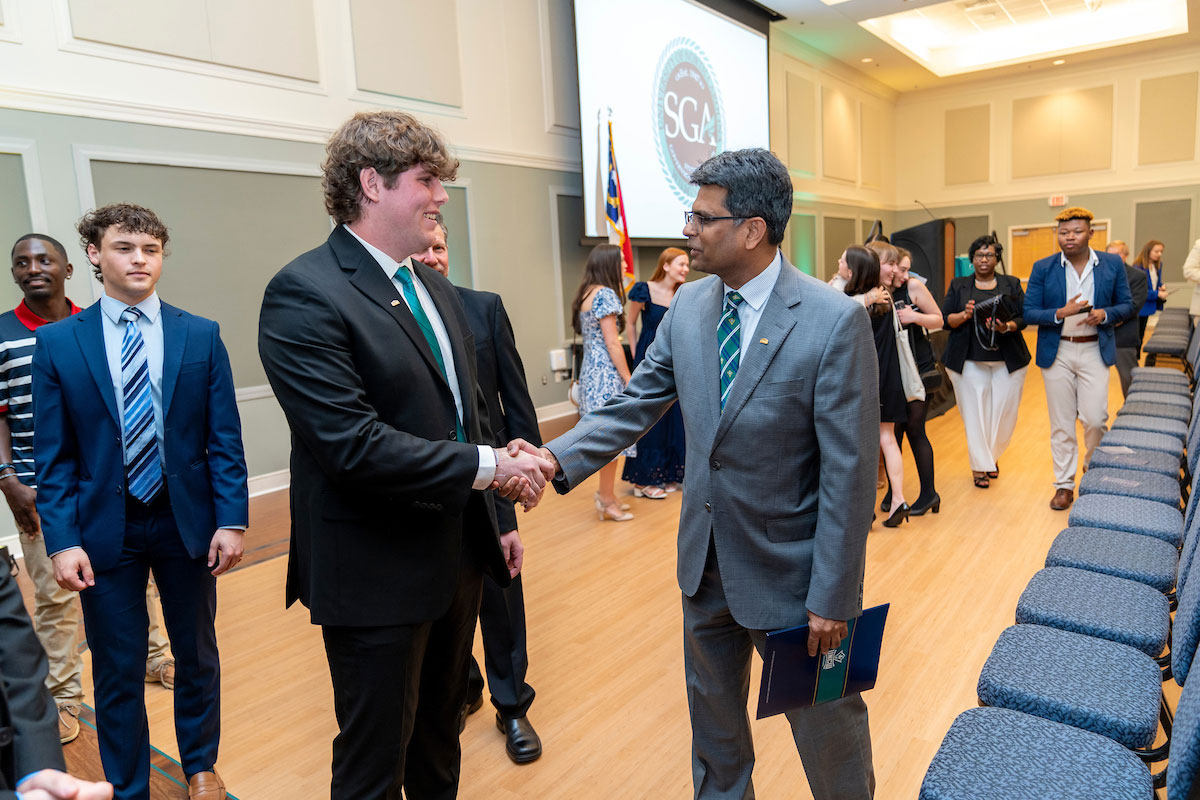 Chancellor Volety shakes hands with Skyler Stein, SGA president