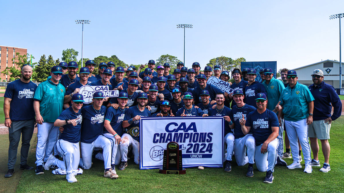 Baseball team and staff pose with CAA championship banner