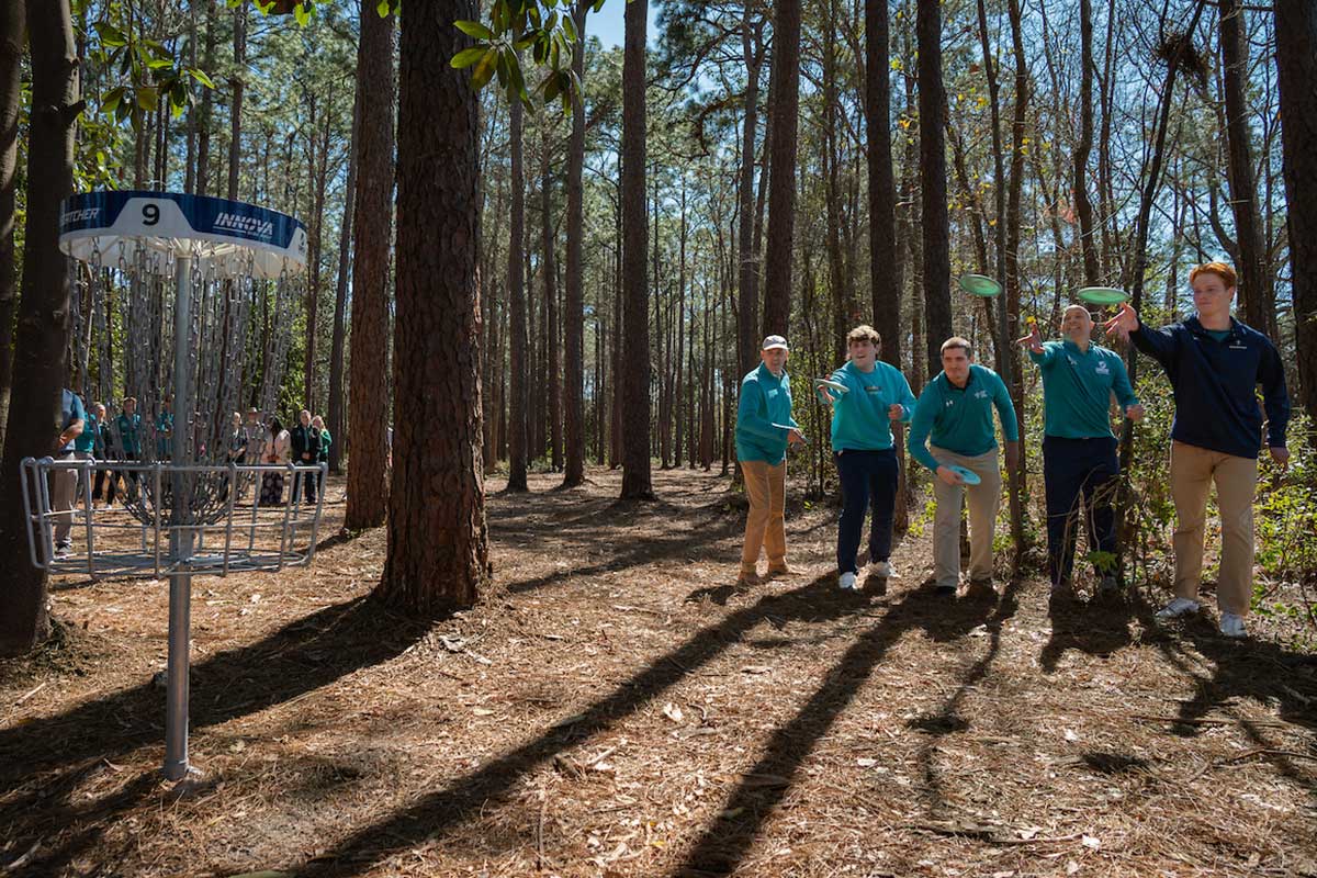 Staff and students throwing the opening toss to officially open the course.