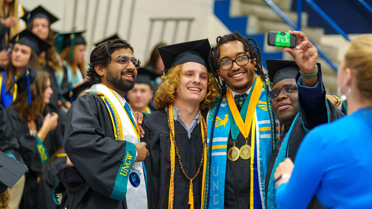 Graduates in robes and stoles pose for a photo together
