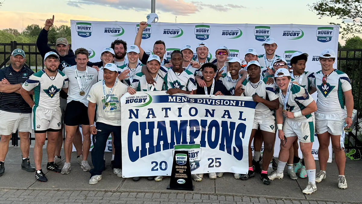 UNCW Men's Rugby Team with national championship banner