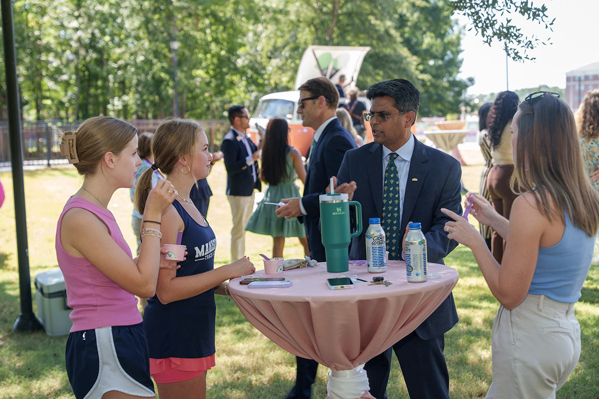 Students enjoy free ice cream while talking with Chancellor Volety outside the new Boombalatti's location at UNCW