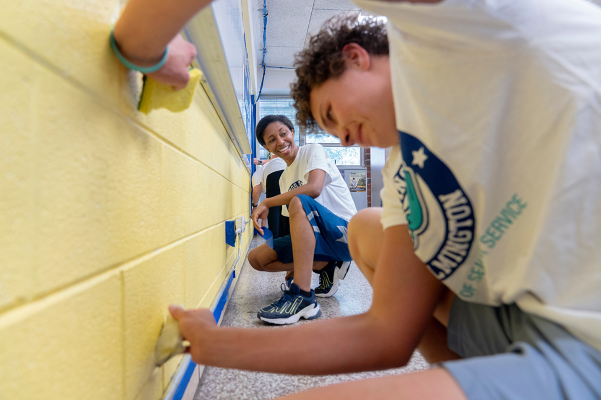Students prepare a wall for painting during Wings Up for Wilmington