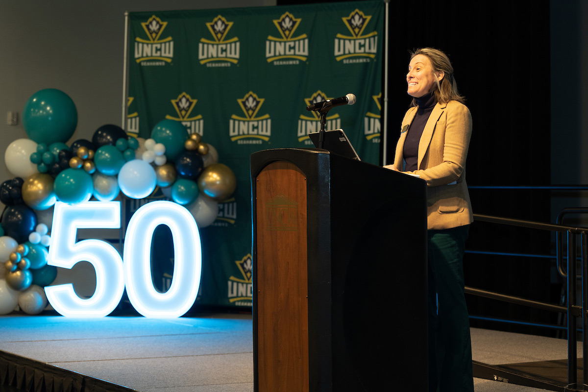 Lindsay LeRoy speaks from a lectern at the Golden Wing Society Reunion & Induction