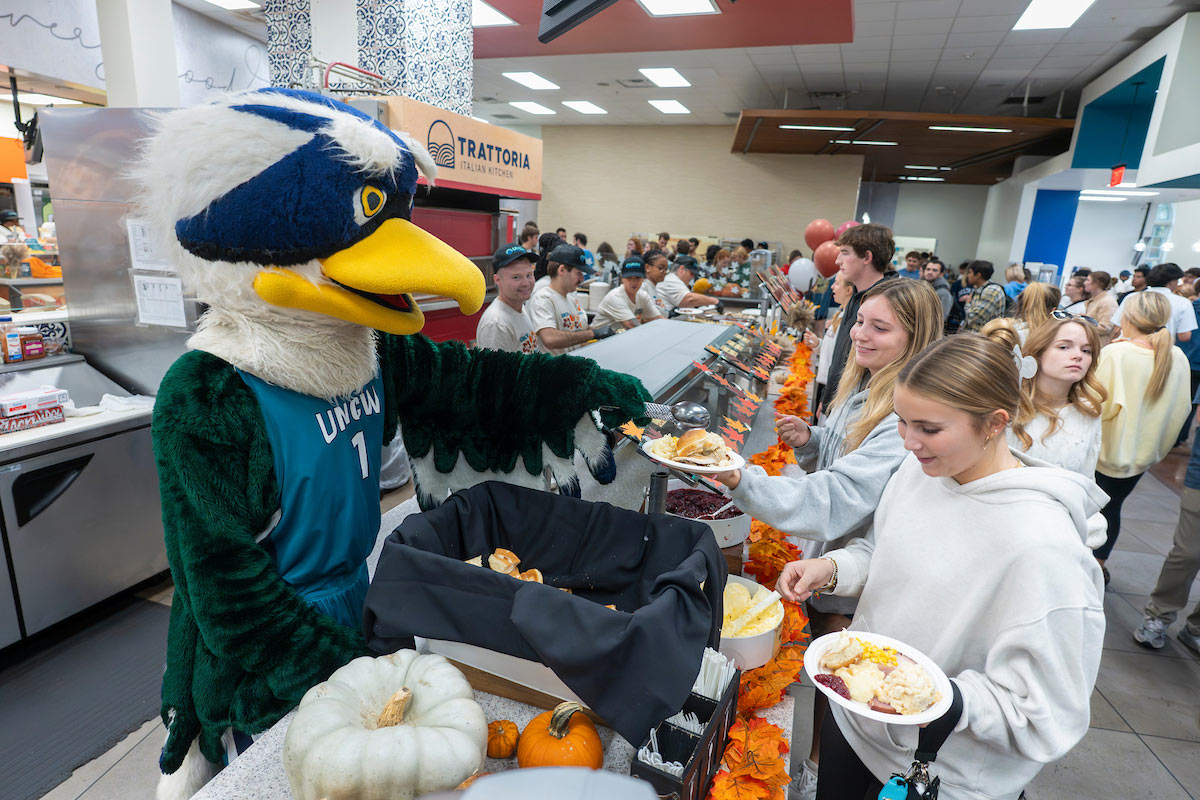 Sammy C. Hawk serves people in line for a Wagsgiving meal at Wagoner Dining Hall