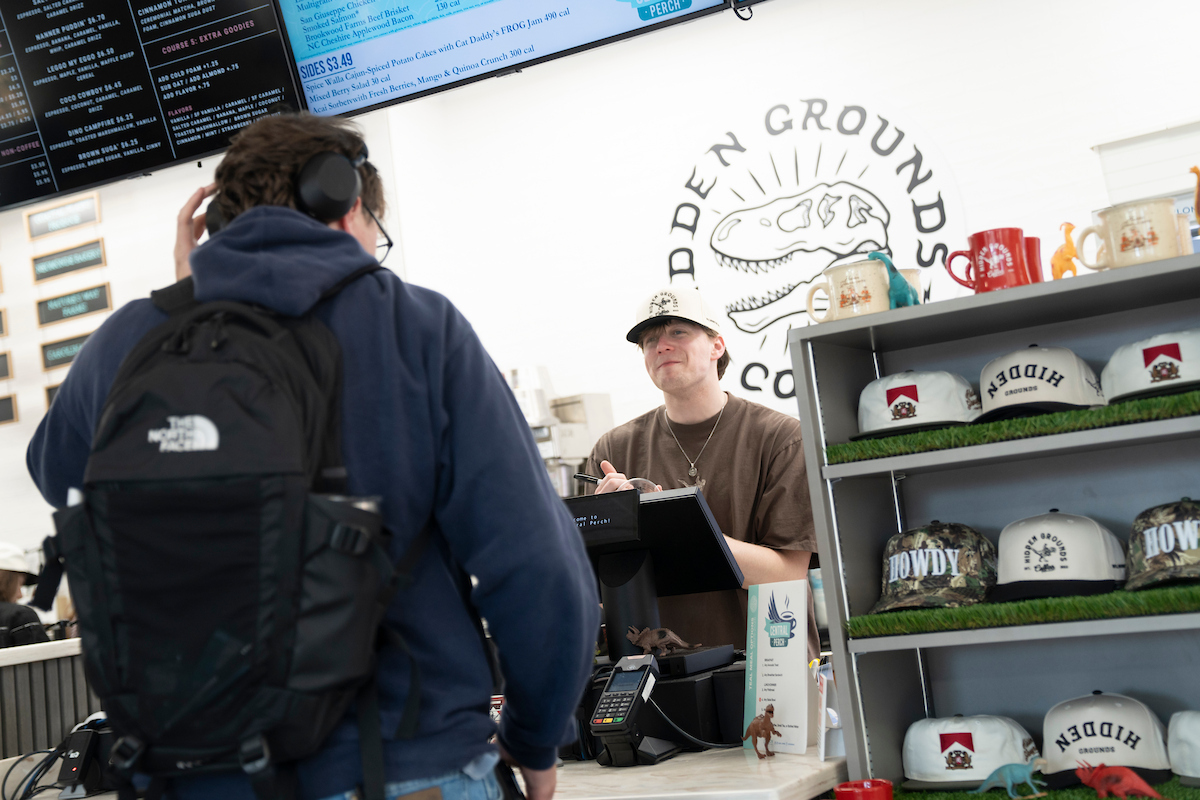 Barista takes an order aat the Hidden Grounds register