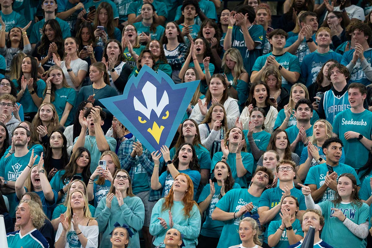 Students pack Trask Coliseum wearing teal and holding up a large Seahawk logo