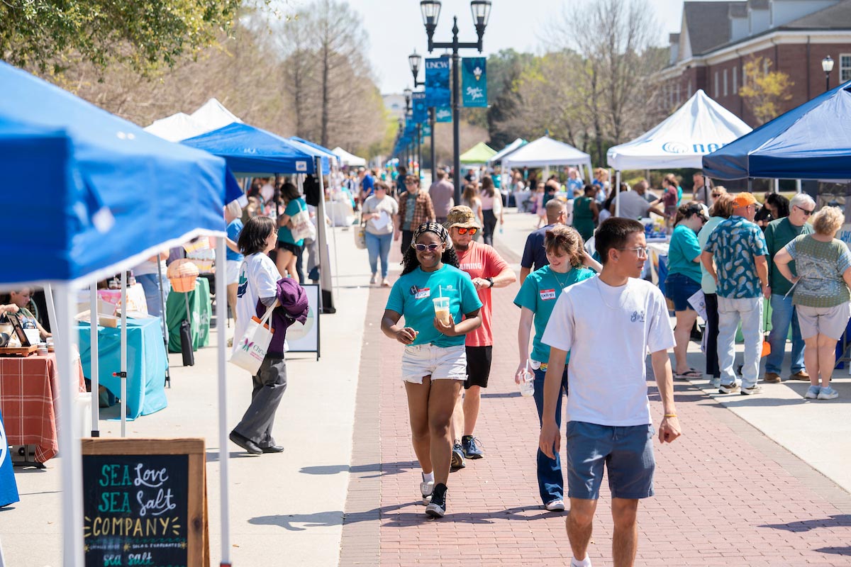 People wander Chancellors Walk visiting booths under tents
