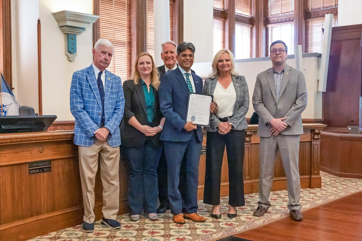 New Hanover County Commissioners and Chancellor Volety with a copy of the resolution