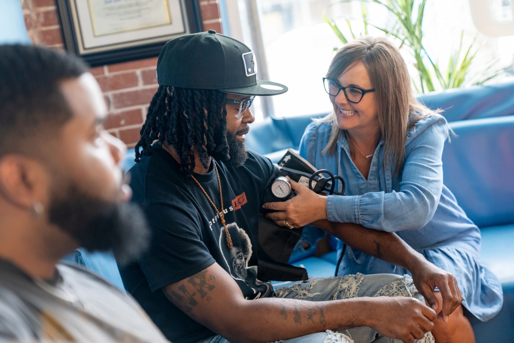Dr. Stephanie Turrise checks the blood pressure of Desmond Hudley a barber at Just Cut It Barbershop on Castle Street in Wilmington.