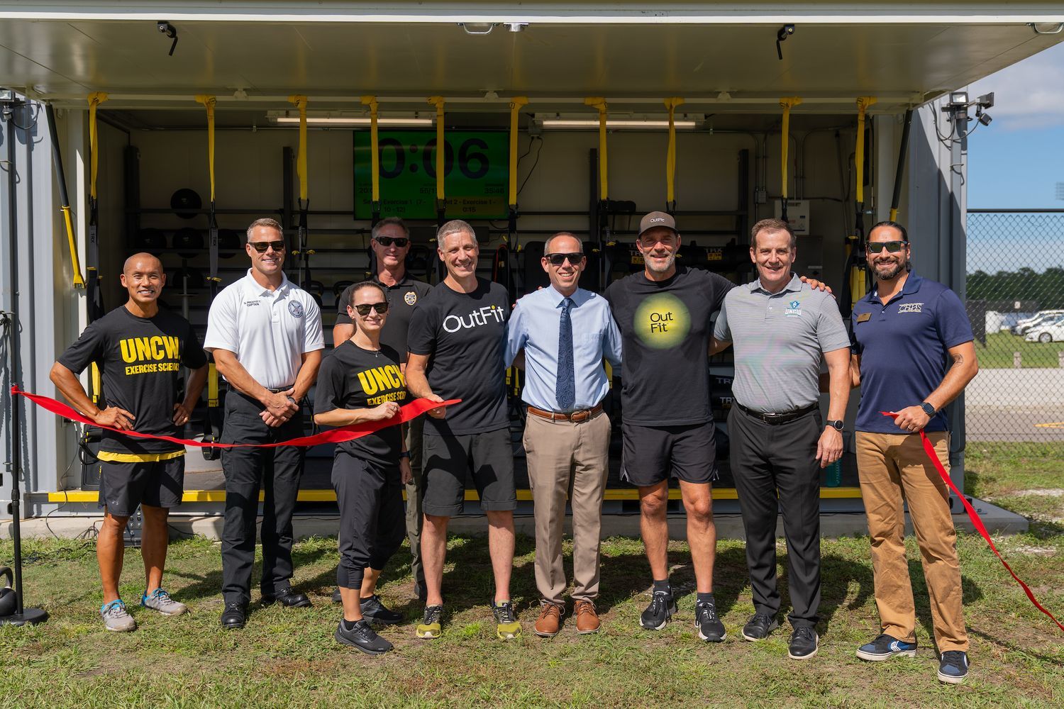 Representatives from the exercise science program, TRX LLC and the New Hanover County fire and sheriff's departments join Dean Jack Watson to cut the ribbon on the OutPost container gym.