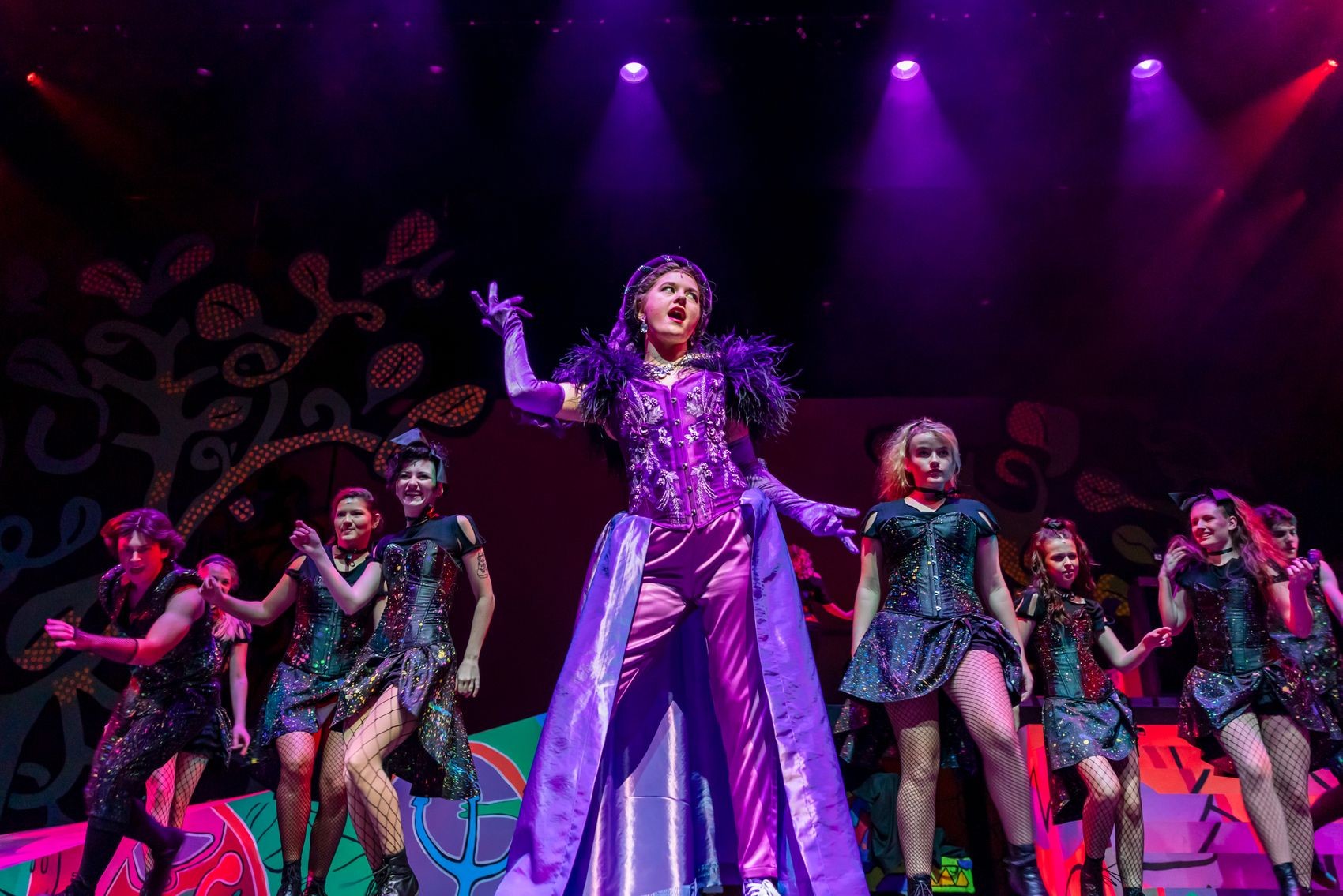 Cast in UNCW's production of the musical "Head Over Heels" perform on a bright and colorful stage.