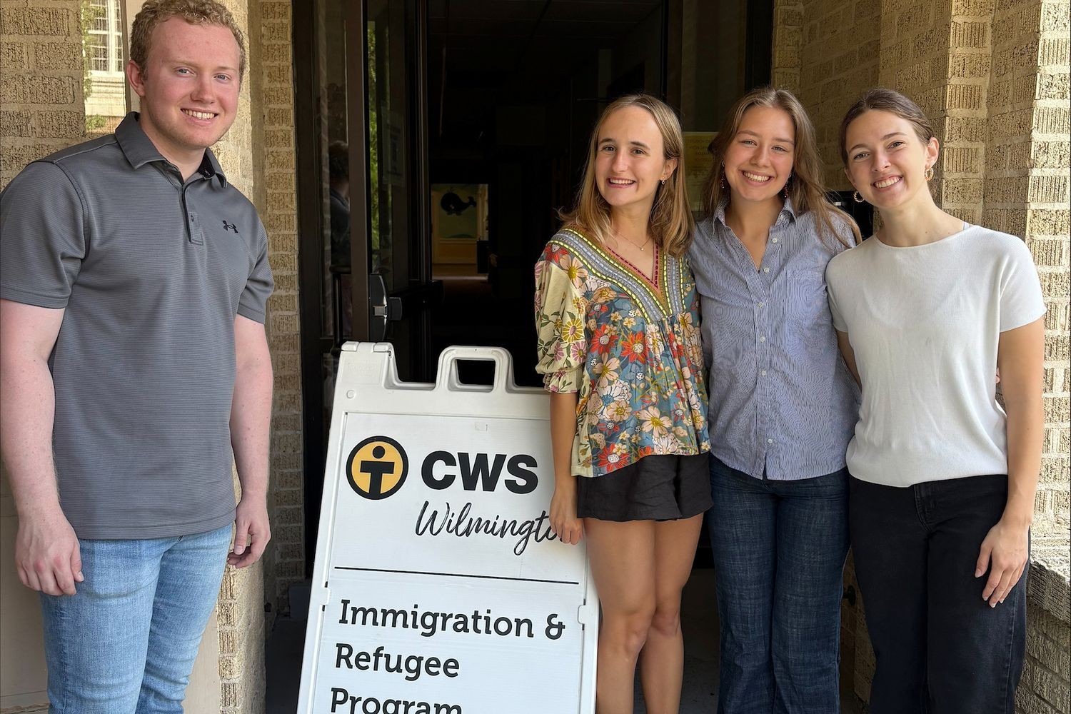 International studies students stand next to the Church World Services Wilmington sign, where they interned in spring 2025. From left: Paul Brady, Catalina Veldwijk, Chloe Travis, and Julia Hauser.
