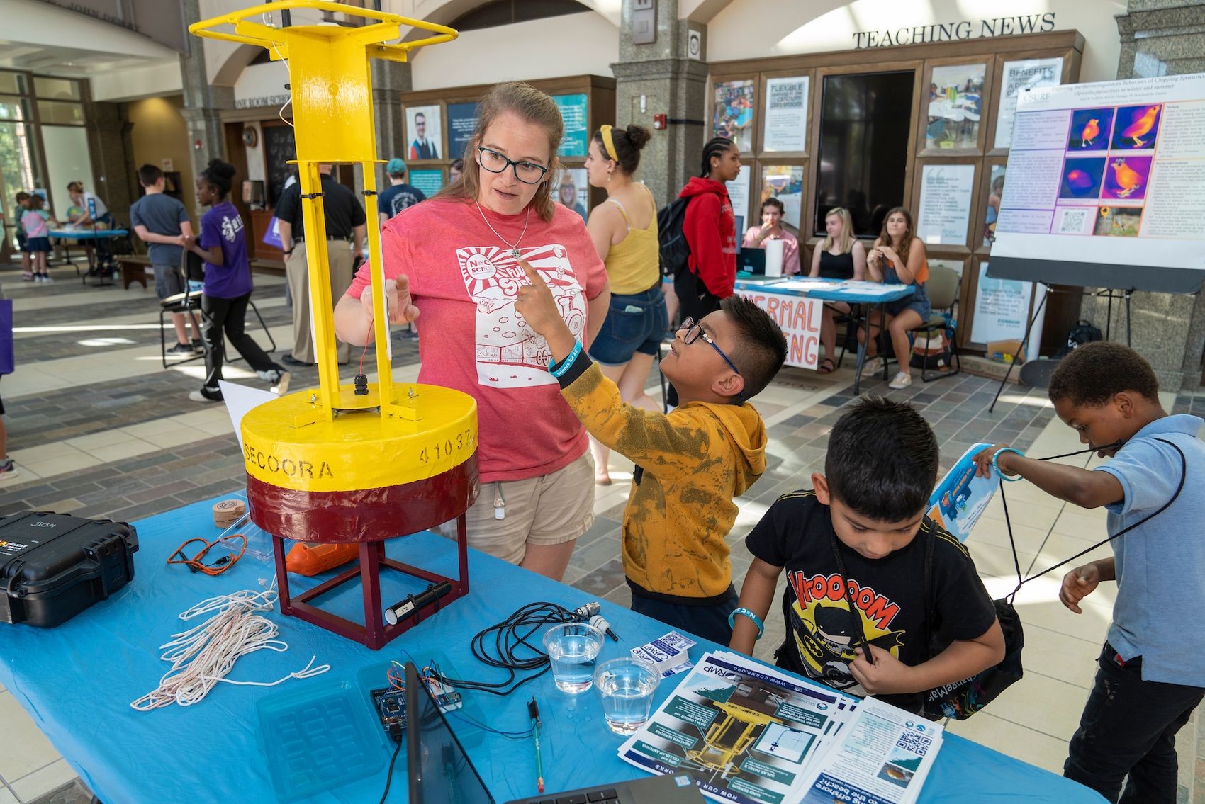 Students look at an ocean bouy with MarineQuest staff