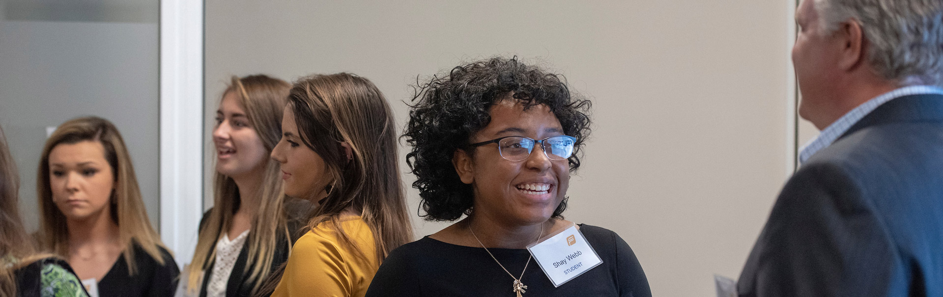 A FuseCR (Center for Clinical Research Workforce Development) student talks with a faculty member at  a reception to connect clinical research community mentors with UNCW students. 