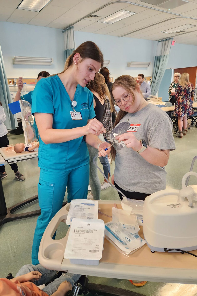 A nursing students talks with an education student in the nursing simulation lab. 