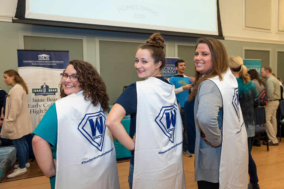 Students wearing teacher capes at event