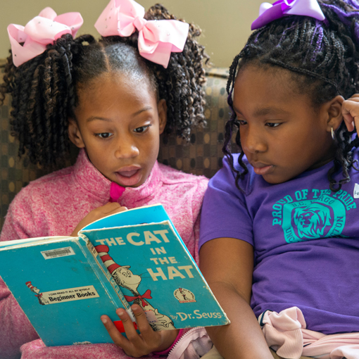 Two children reading a Dr. Suess book