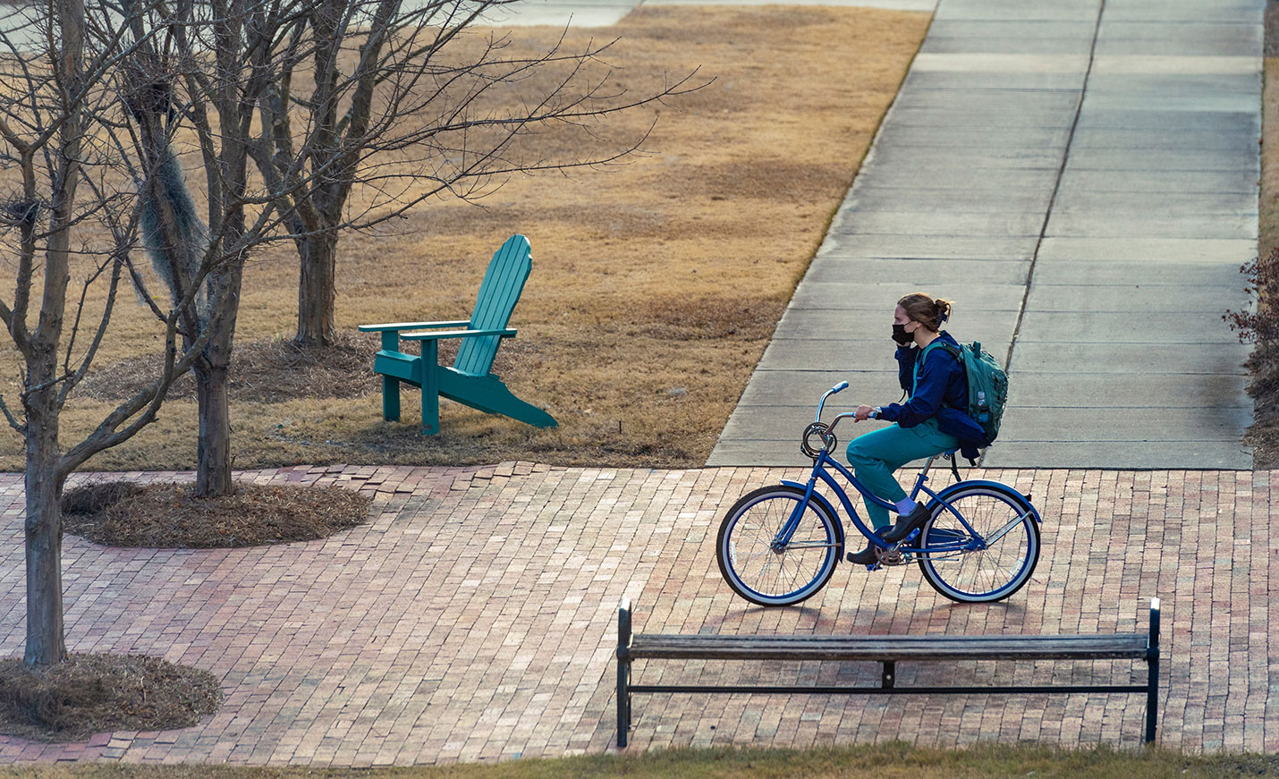 A nursing student rides their bike to class.