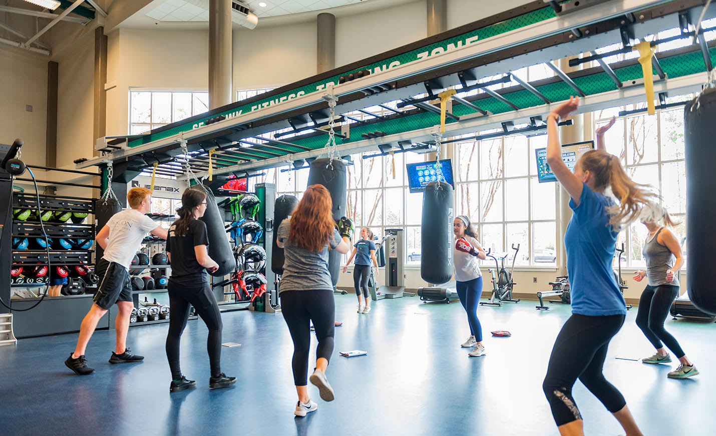 A fitness class practices with boxing gloves and bags.