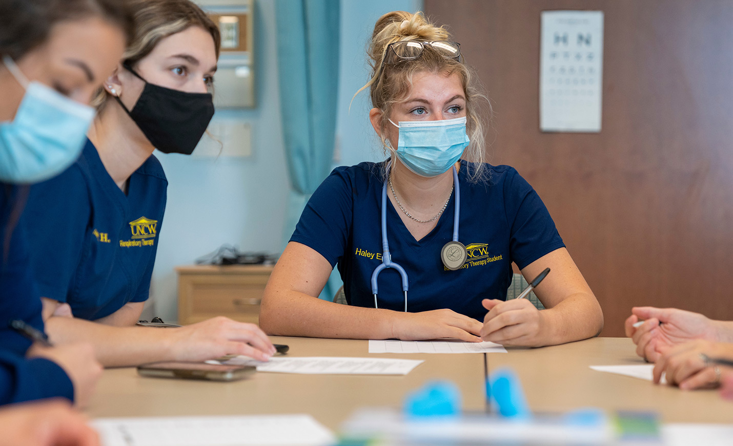 Respiratory therapy students sit together taking notes.