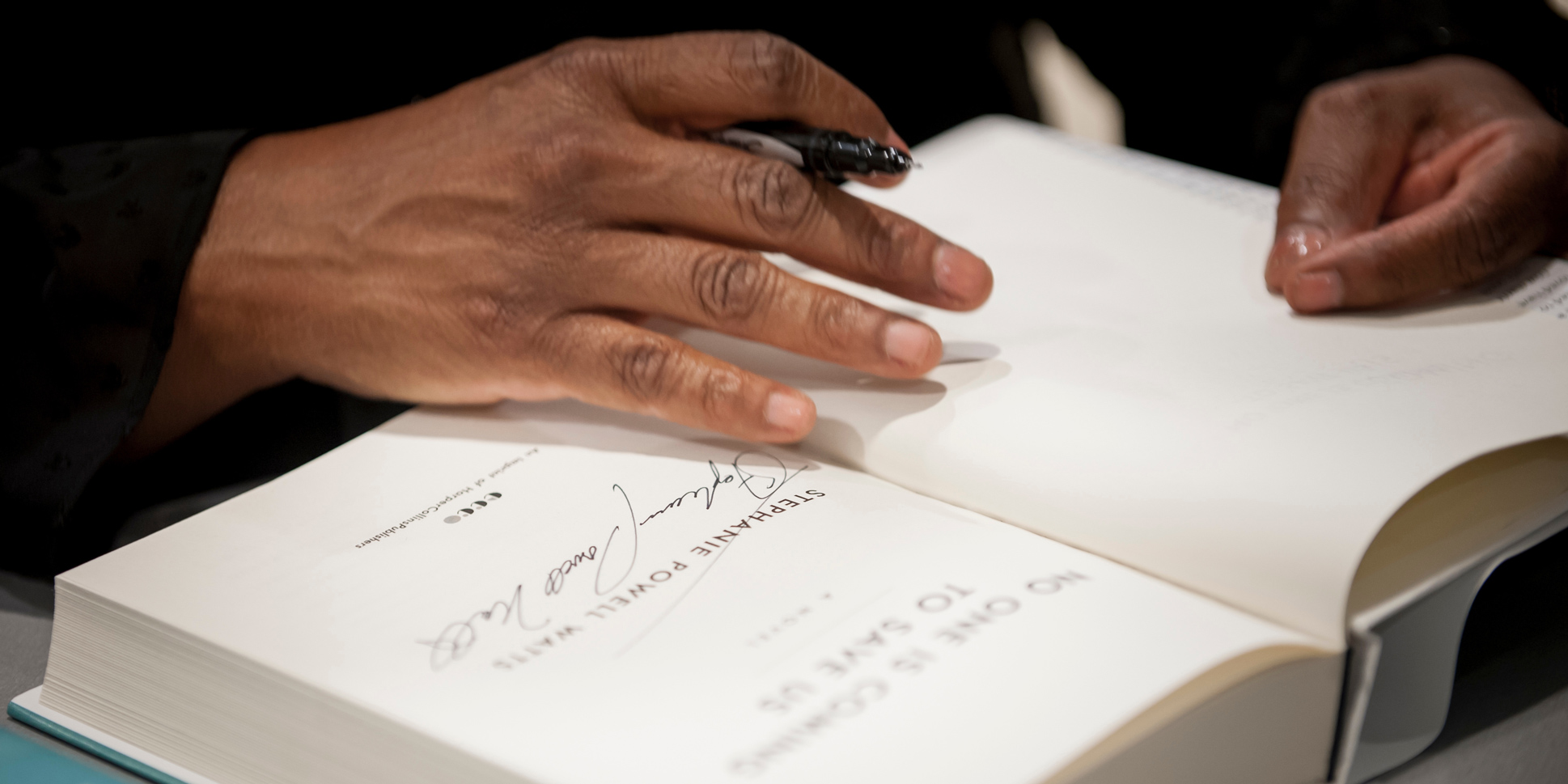 A writer autographs a book 