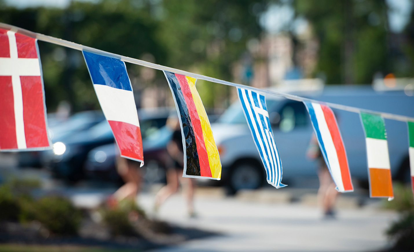 a line of international flags blow in the wind