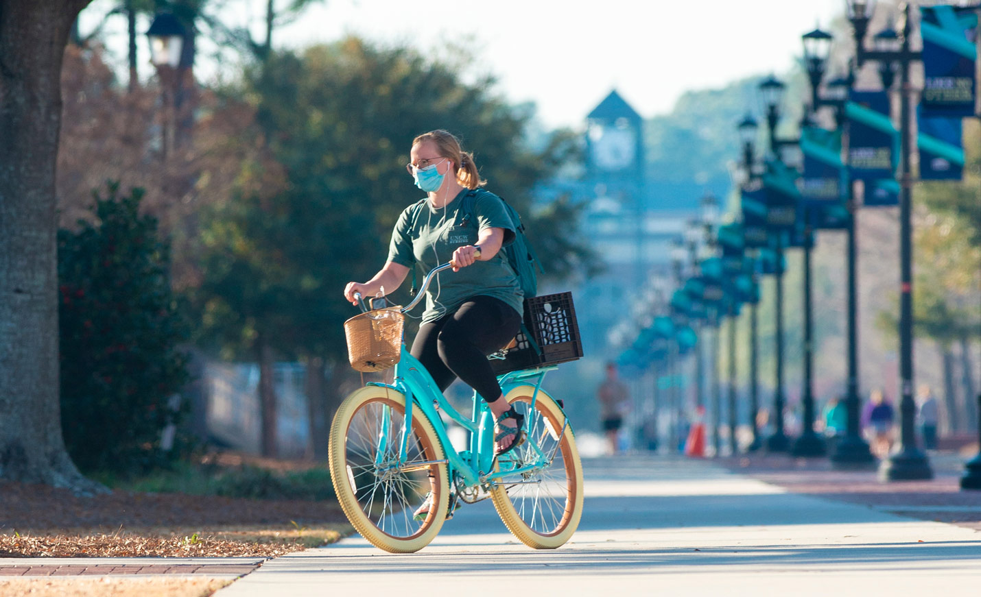 student riding teal bike on Chancellor's Walk