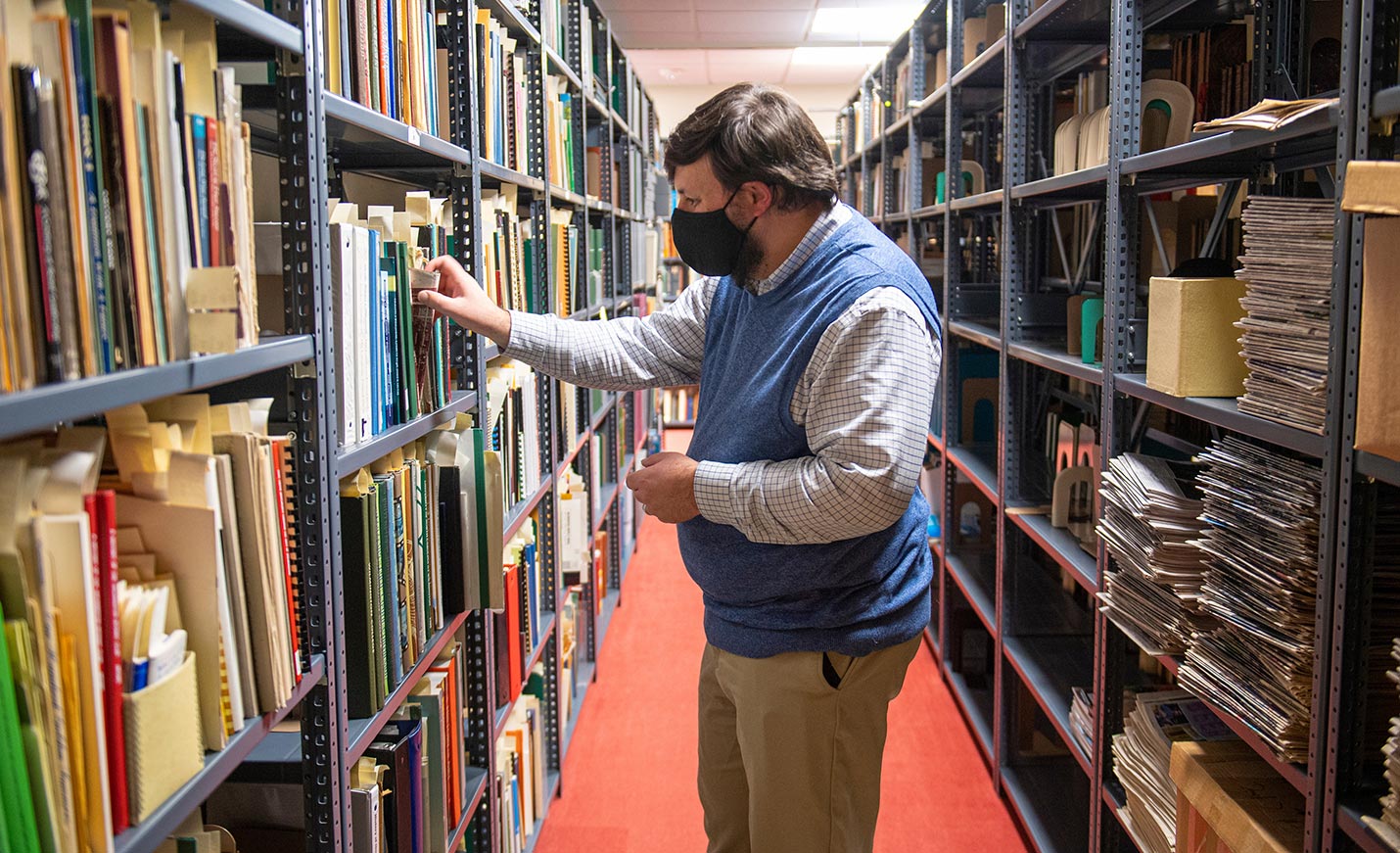faculty member looking through the stacks in Randall Library