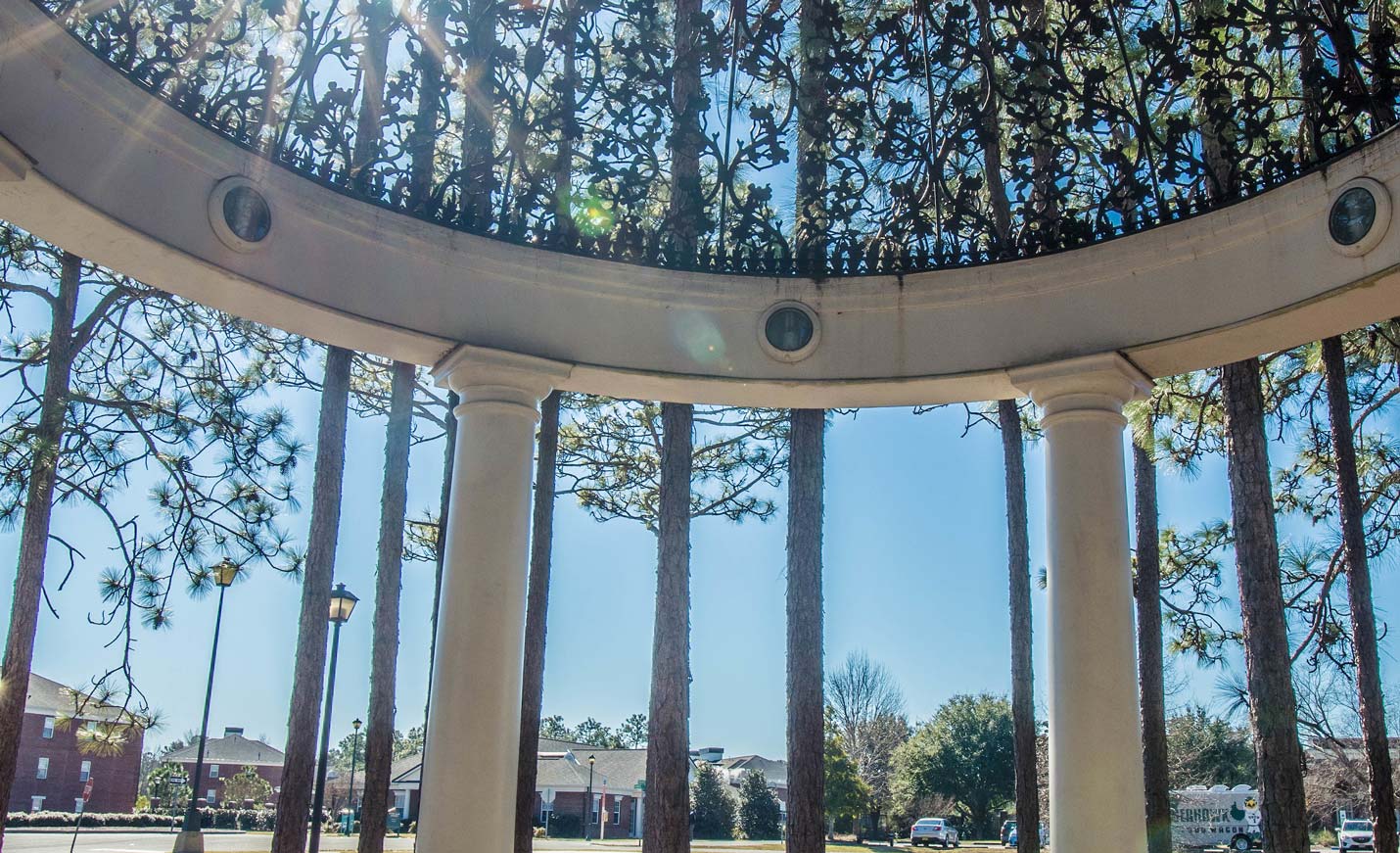sun shines through the gazebo by the student residence halls