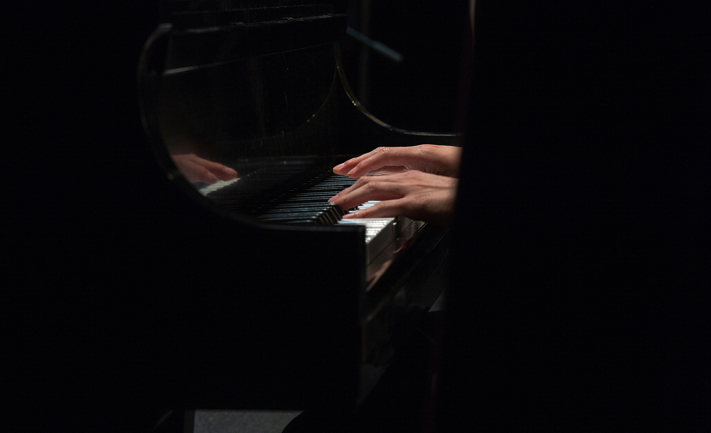 student hands on a piano keyboard