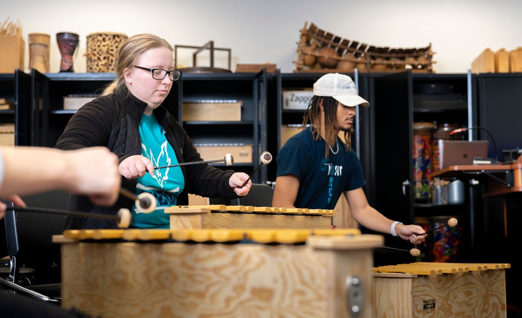 Students hammering on wooden xylophone-like instruments