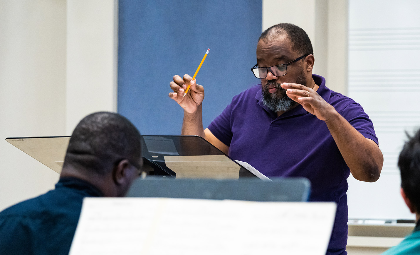 A composer orchestrating during a rehearsal