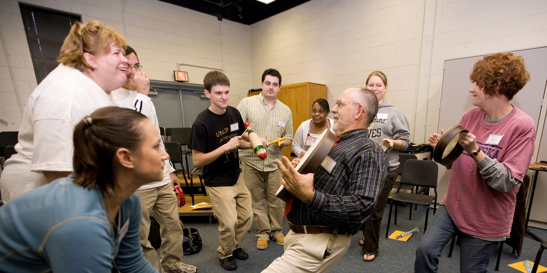 Group photo of music students hitting a drum