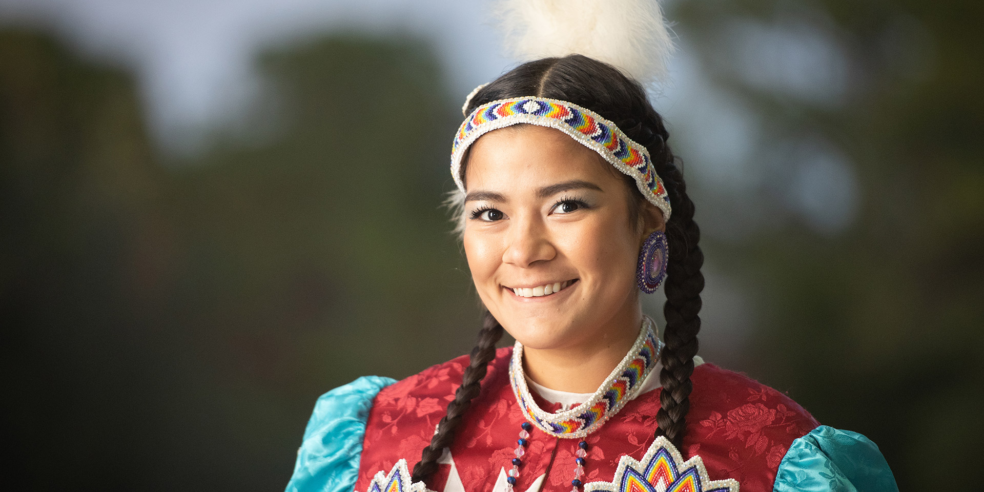 A Native American student dressed in clothing representative of her culture