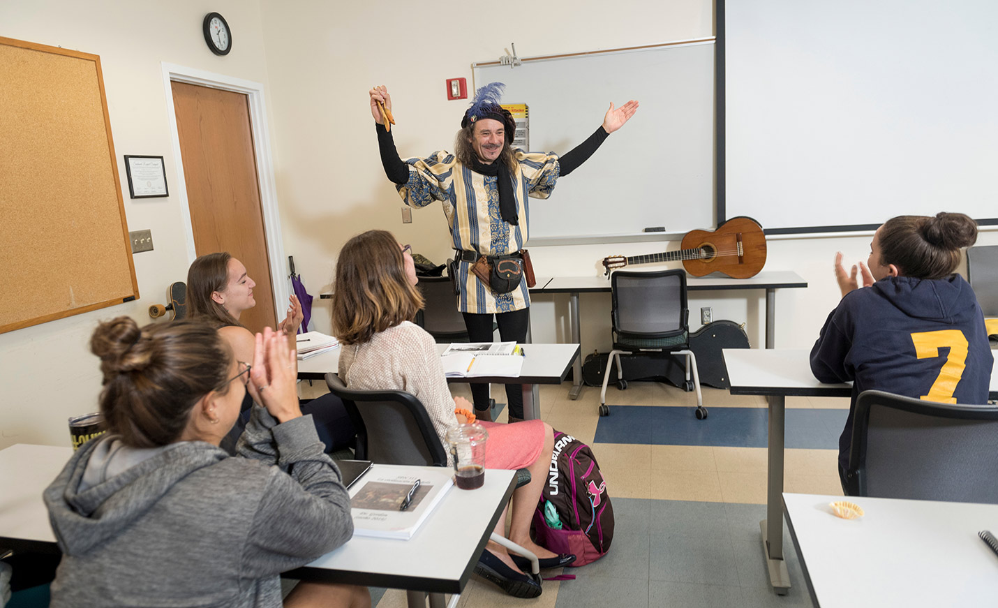 A man dressed as Don Quixote uses animated gestures as he stands in front of a class 
