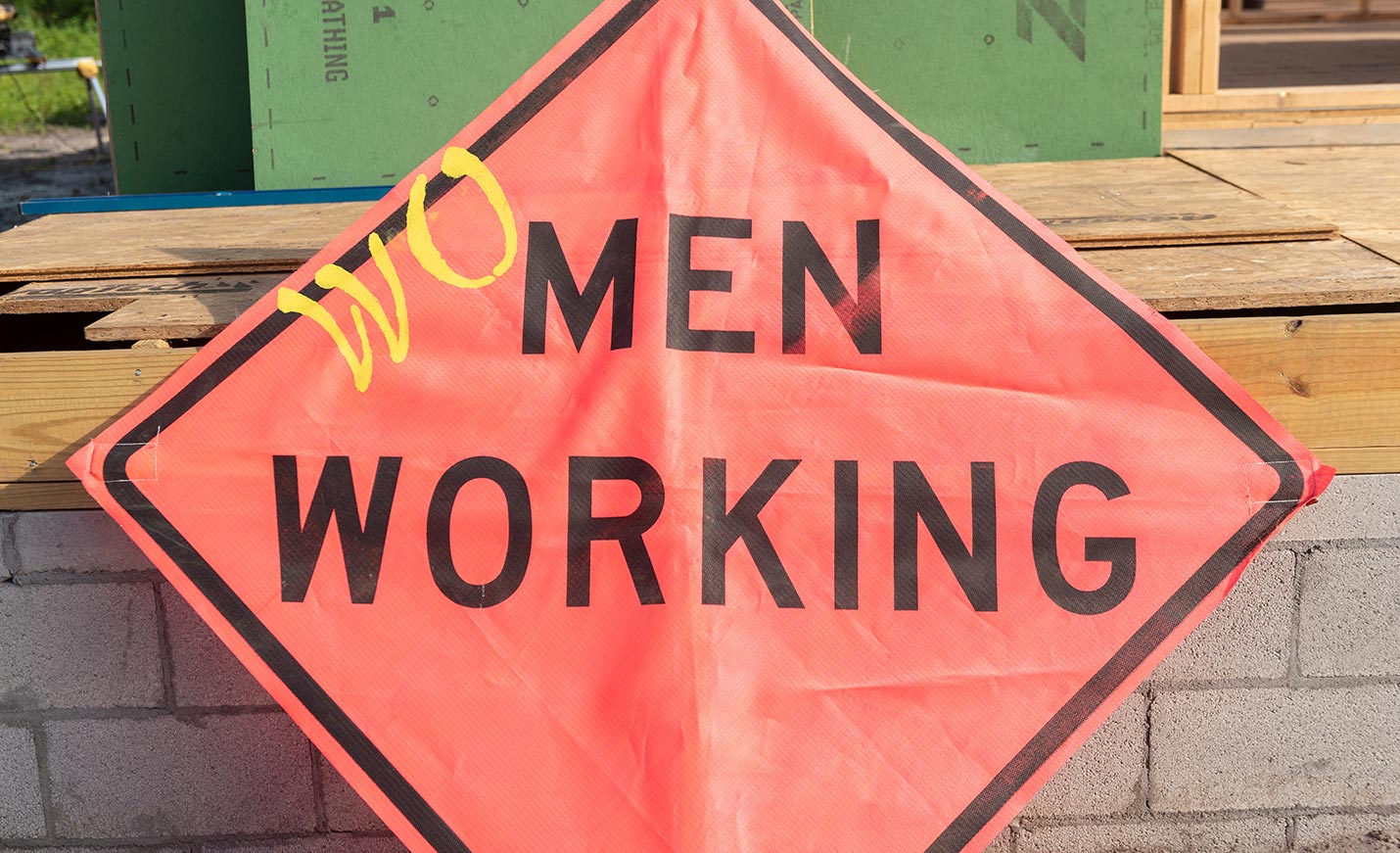 Orange Men Working sign modified to say Women Working