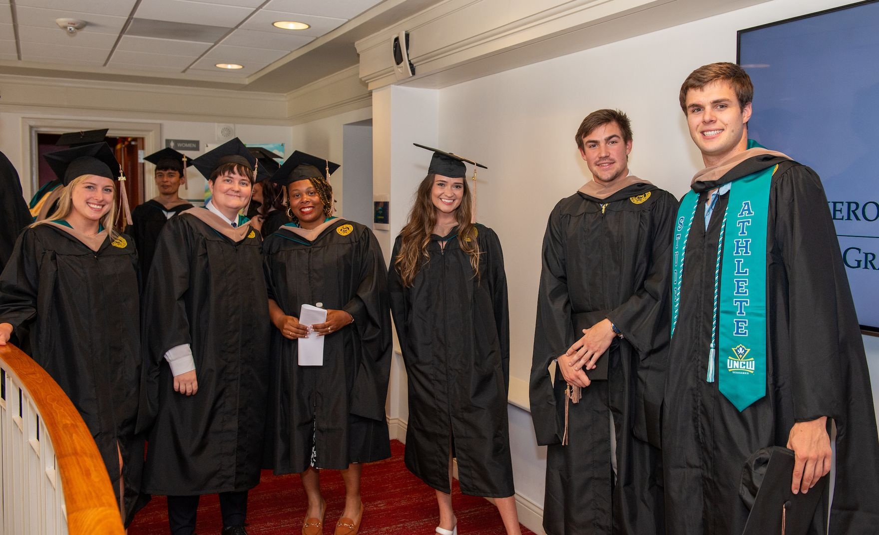 CSB MSAC grads posing together in preparation for commencement