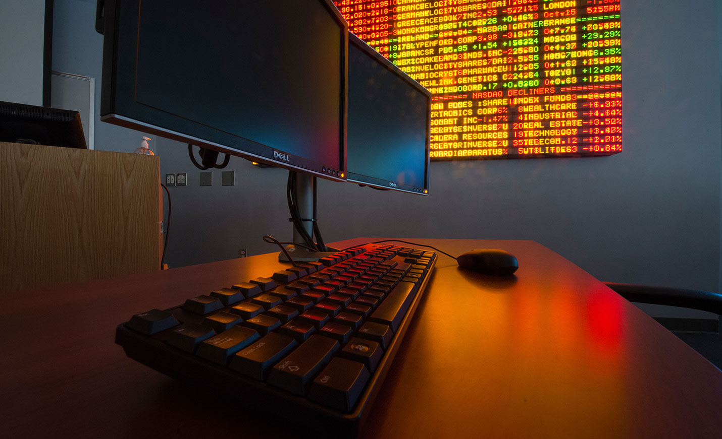 Two computers and a stock ticker board