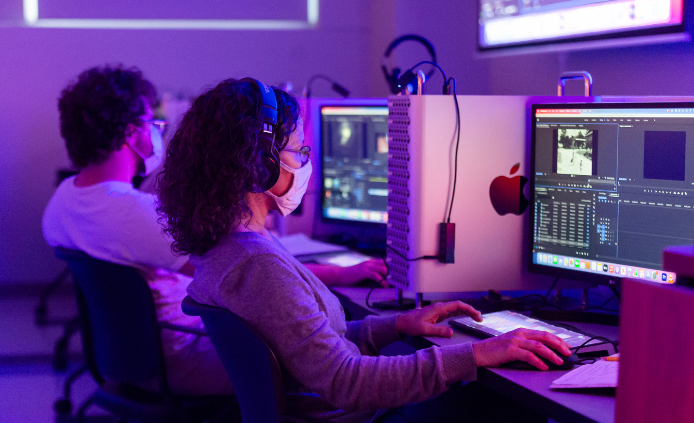 Two people in a darkened room with a purple aura working on desktops; caption over the photo reads FURTHER YOUR EXPERIENCE IN COMPUTER SCIENCE AND INFORMATION SYSTEMS