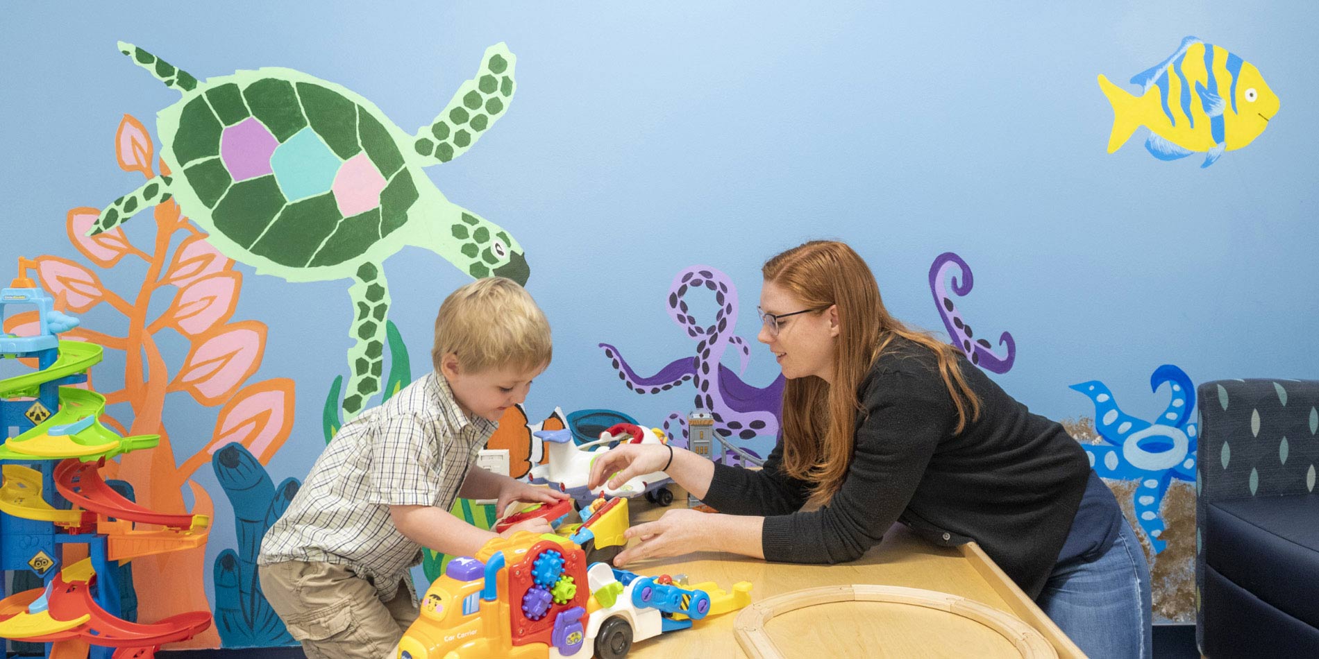 Child plays with toy in classroom.